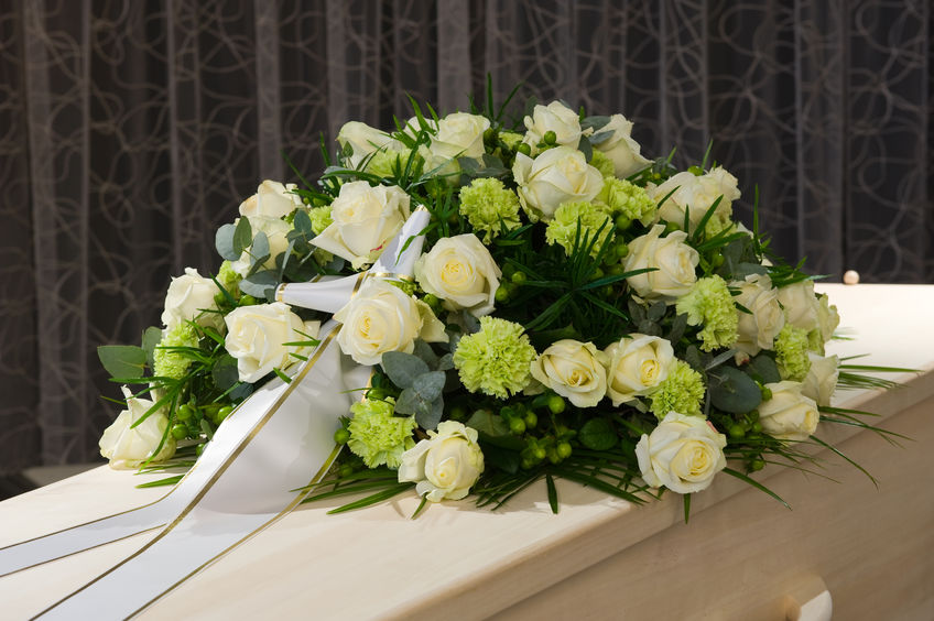 52023244 - a coffin with a flower arrangement in a morgue