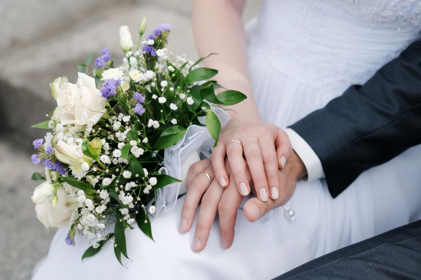 9979073 - bride and groom's hands with wedding rings and bouquet of flowers