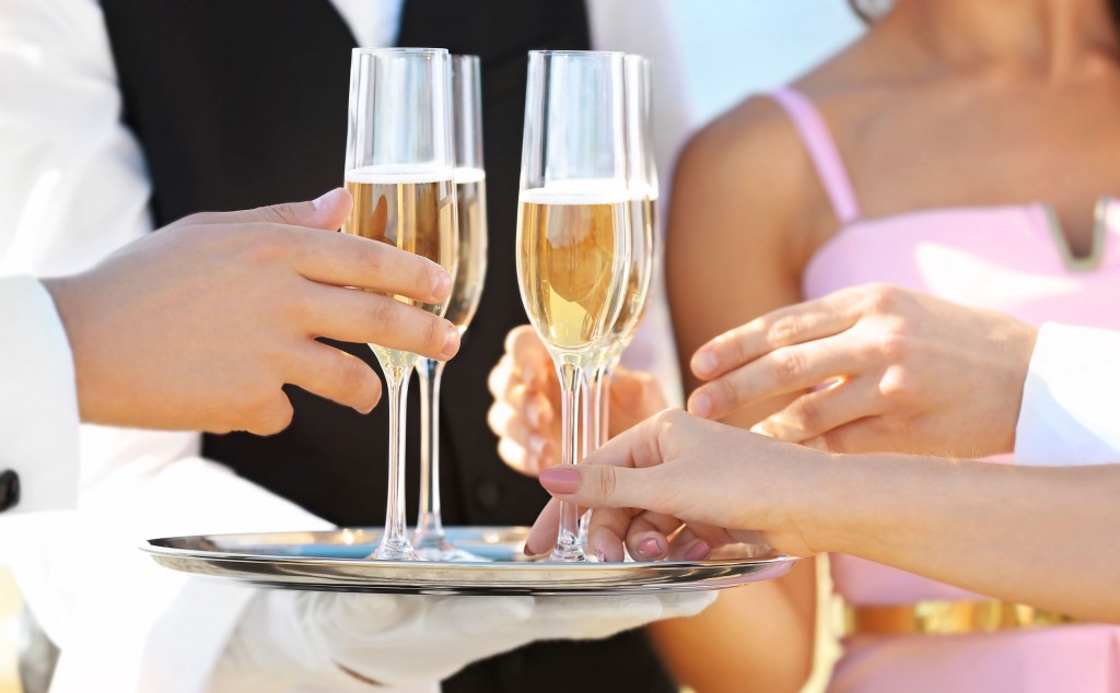 97092489 - waiter offering champagne to guests at party, close up view